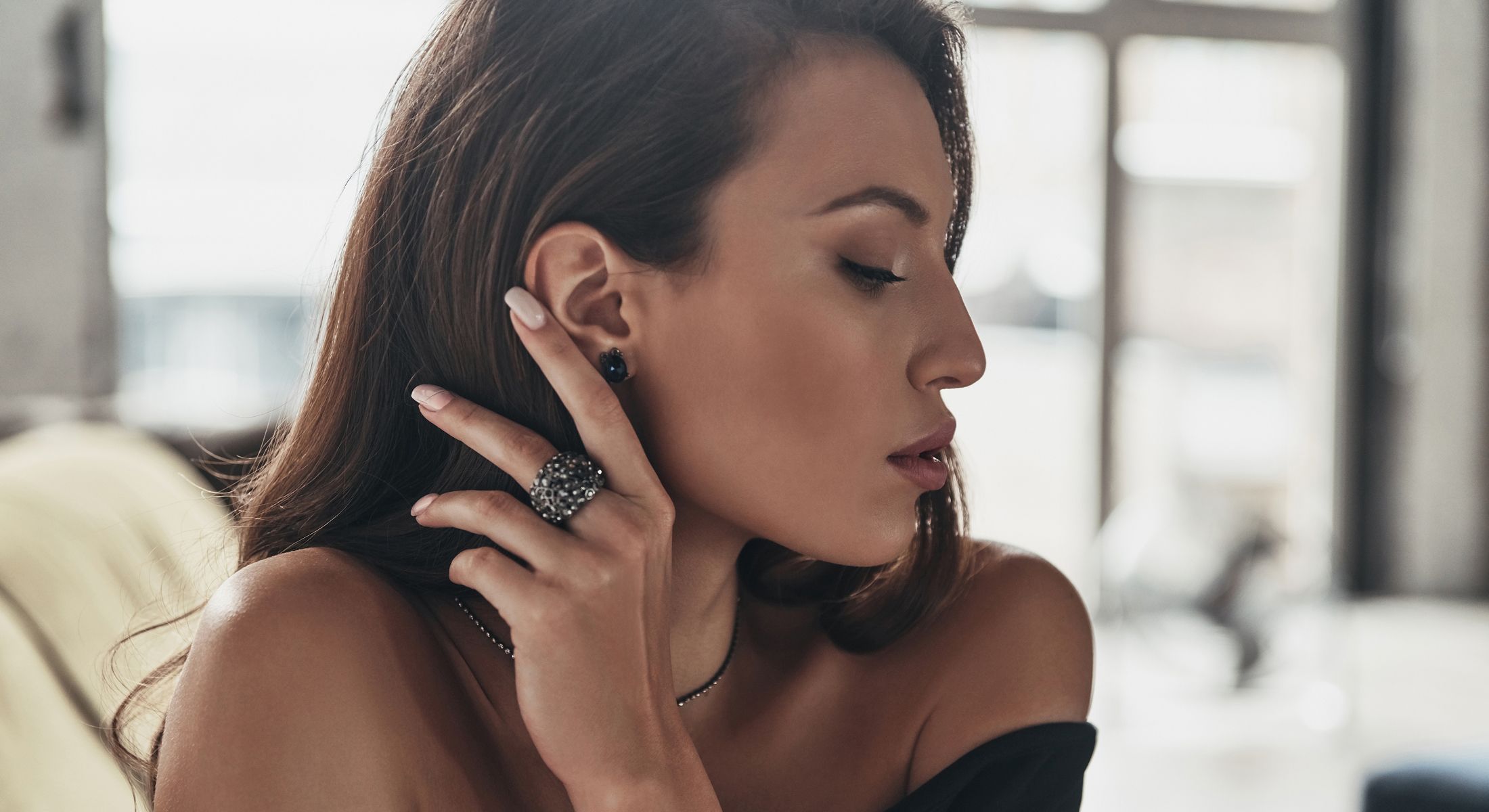 Woman wearing elegant jewelry, side profile view.