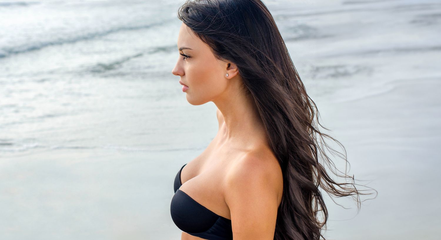 Woman with flowing hair by the water.