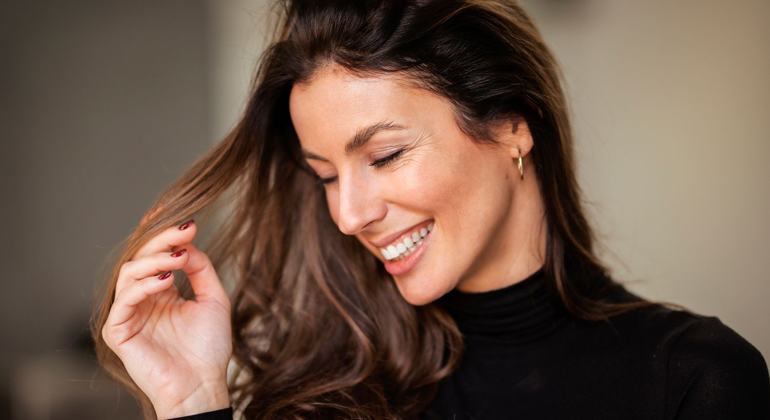 Woman with long hair, softly gazing at viewer.