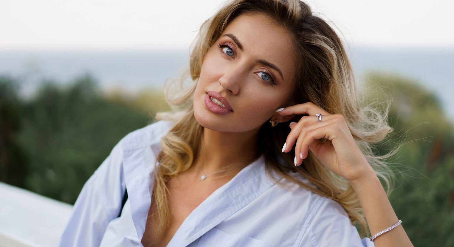 Woman with tousled hair against a blue background.